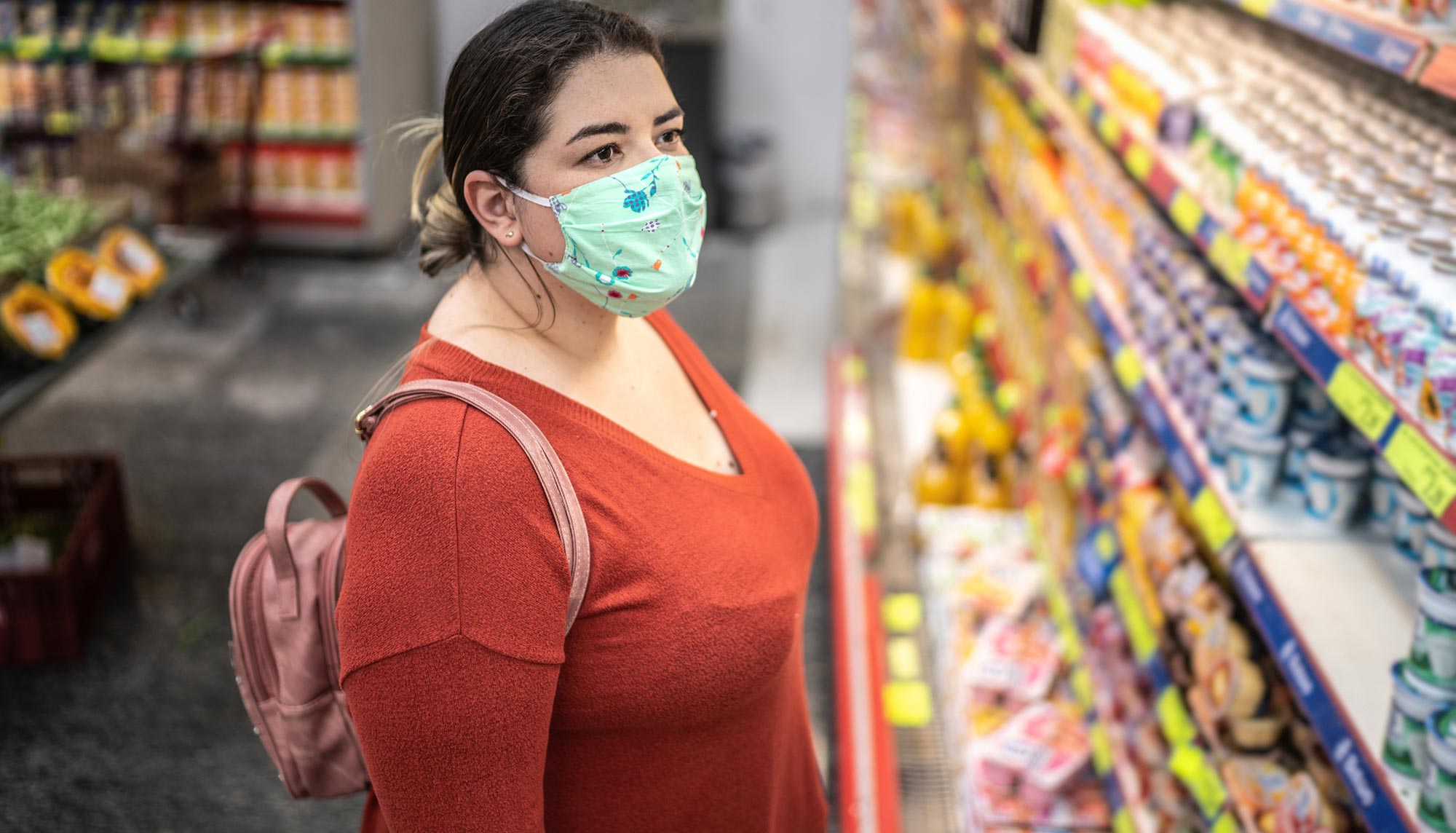 Woman grocery shopping wearing a face mask
