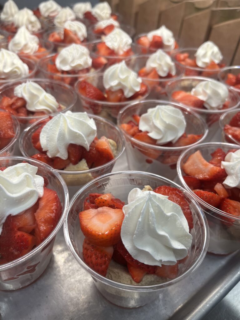 small cups of strawberries with whipped cream