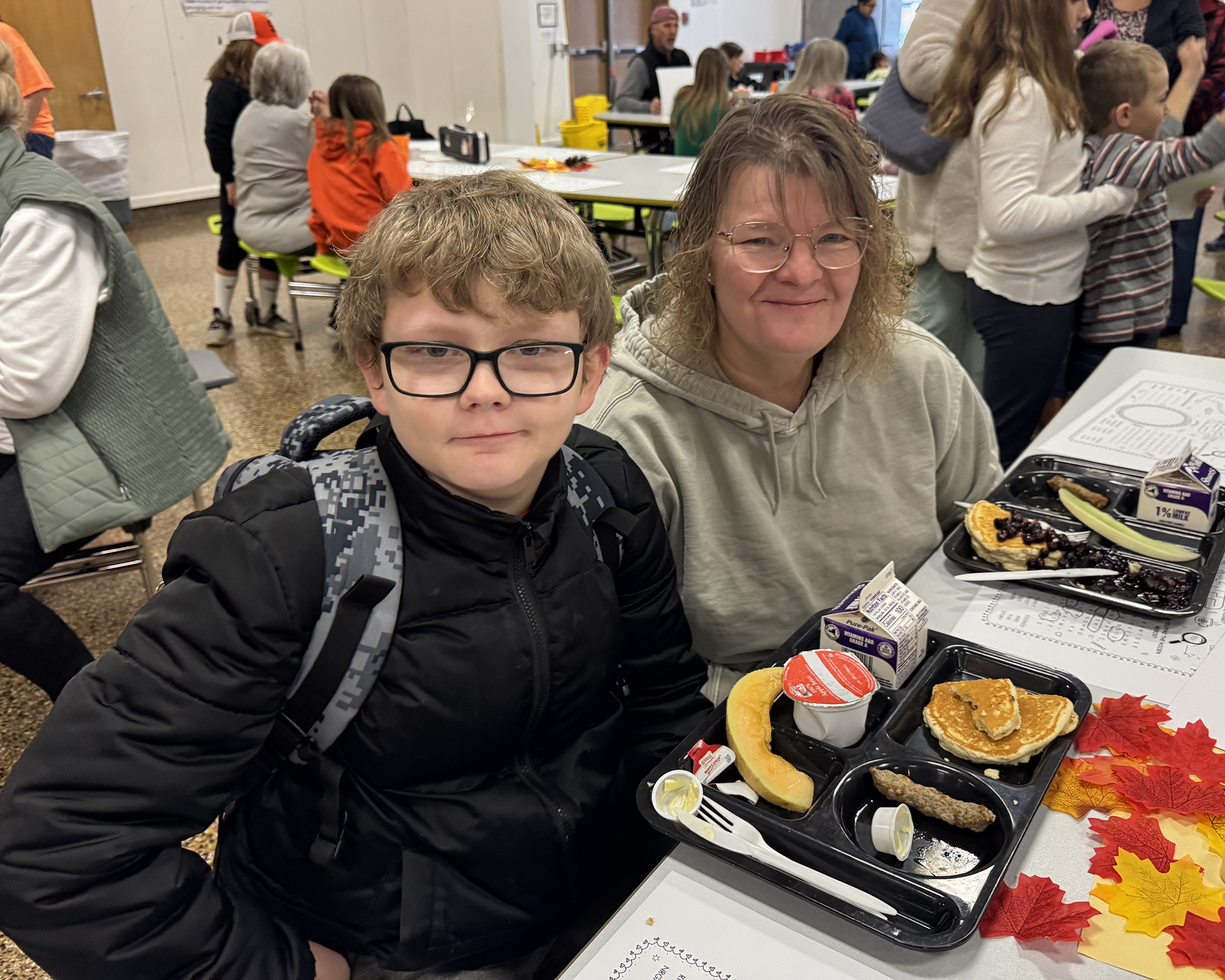 Child and grandparent eating school breakfast