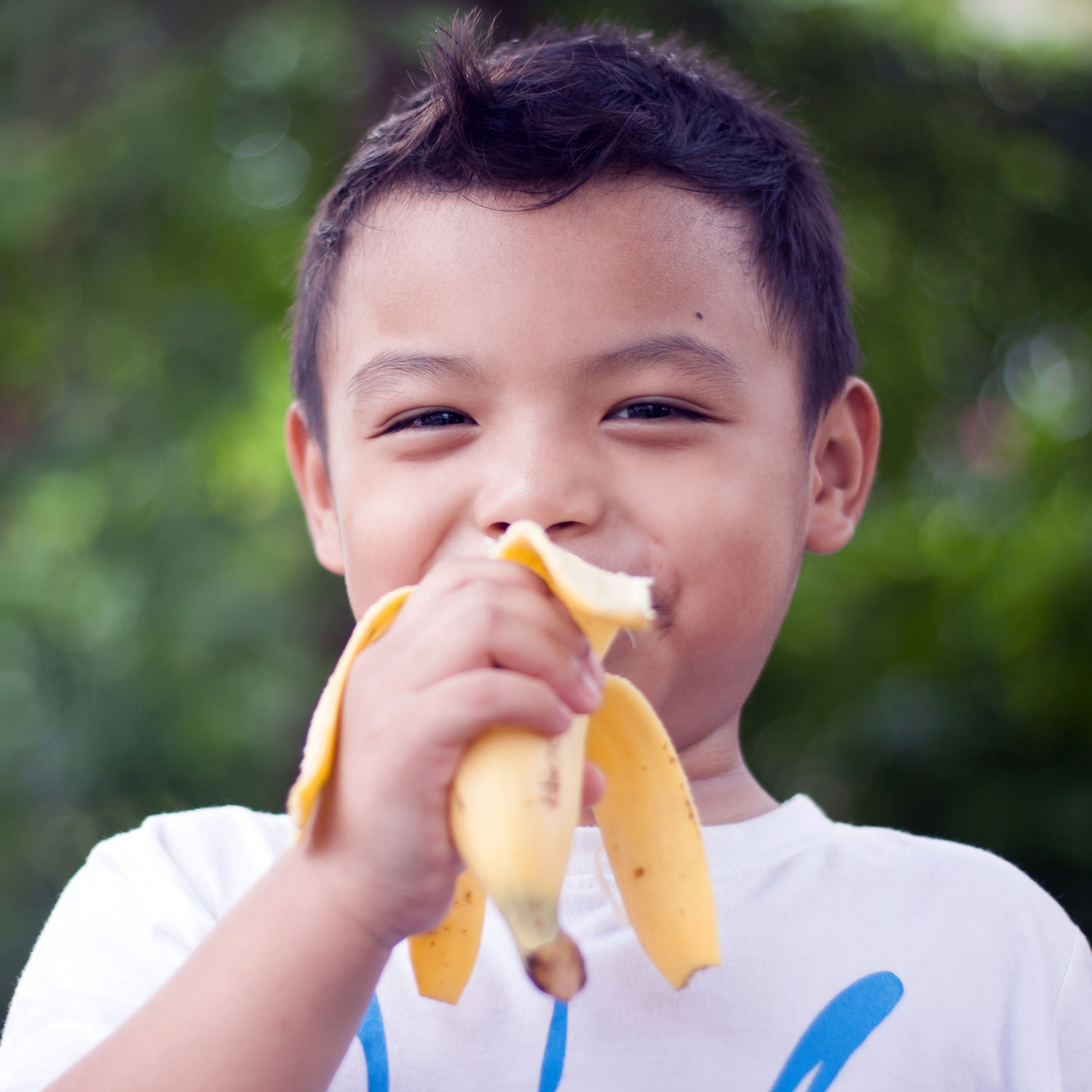 child eating a banana outdoors